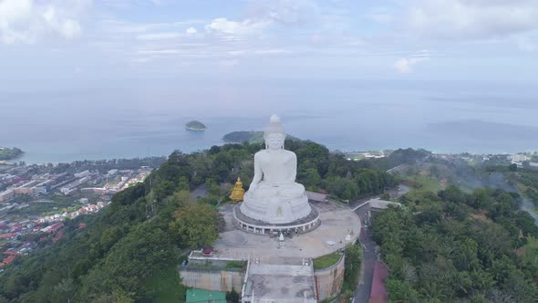 Aerial View drone shot of White Marble Big Buddha Statue on the high mountain peak at Phuket thailan