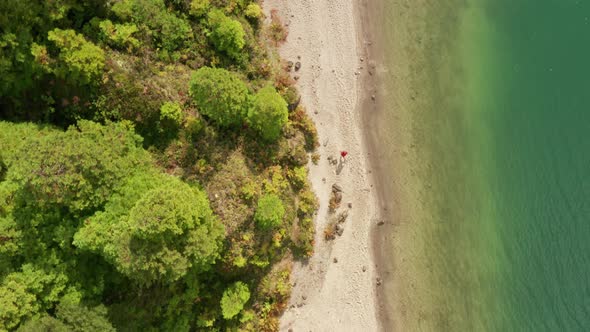 Aerial View of a Man Walking Across a Sandy Beach