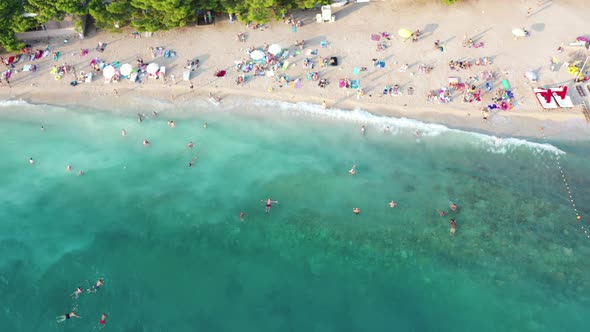 Aerial top down view of people swimming in sea, relaxing at the brach