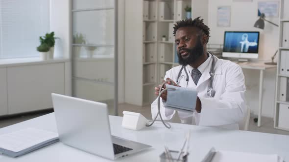 African American Doctor Working With Patient Online