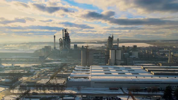 Aerial View of Cement Plant with High Factory Structure and Tower Crane at Industrial Production