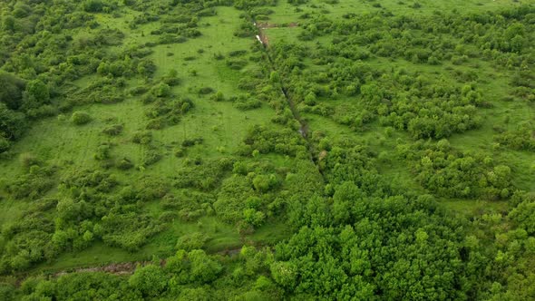 Aerial drone view of the irrigation canal system on a picturesque green meadow