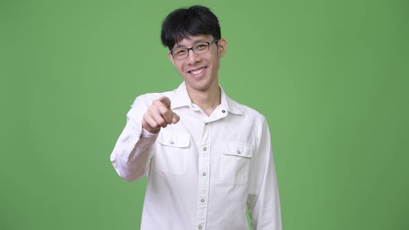 Young Asian Businessman Smiling and Pointing To Camera