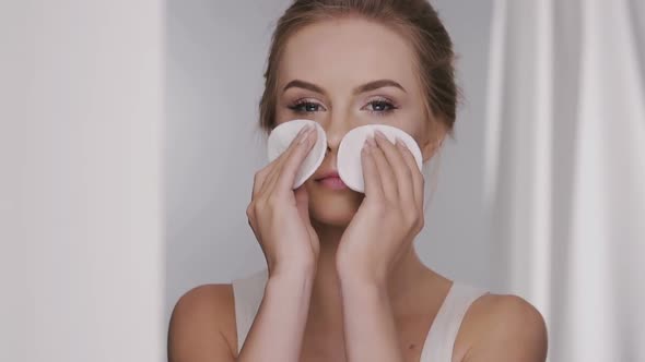 Girl Removing Make-up with Two White Cotton Pads