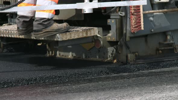 Asphalt paver machine working on the road construction site
