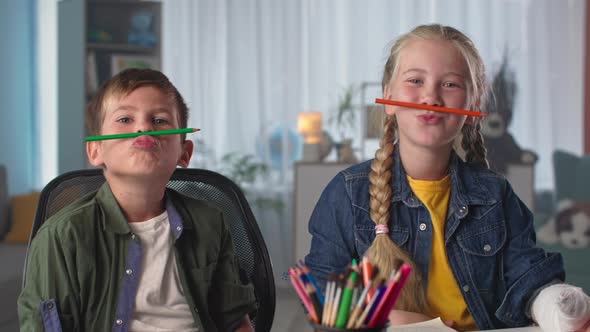 Cheerful Children with Colored Pencils Have Fun Together Close Up Happy Boy and Girl Fool Around