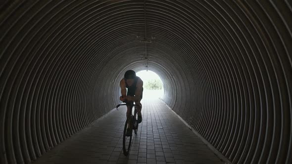 Pro Triathlete Rides a Cutting Bike Pro Cyclist Rides in a Tunnel Athlete Training for Race Slow