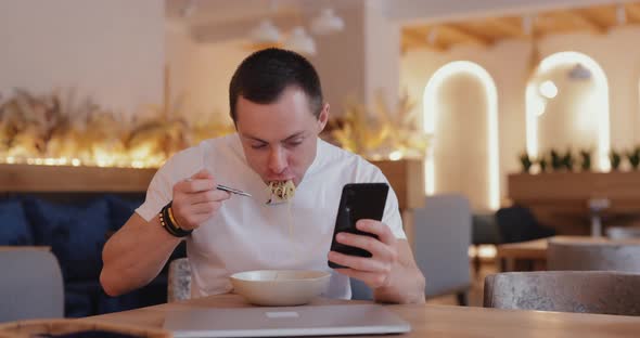 A Man Does Not Part with His Phone Even While Eating