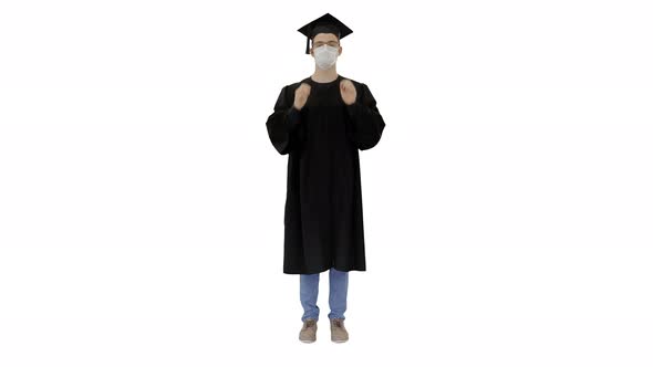 Young Man with Graduation Gown in Medical Mask on White Background