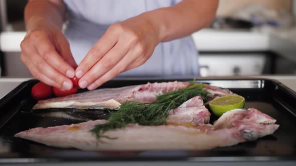 Sea Bass Fish with Lime Slices Dill and Tomatoes Cherry Over Baking Sheet