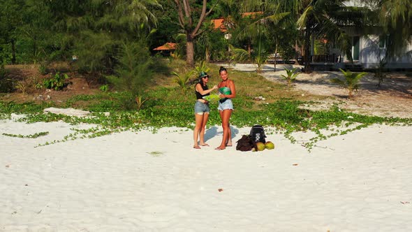 Young Smiling Ladies Relaxing Having Fun on The Beach on Paradise White Sand and Blue