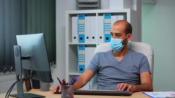 Manager with Face Mask Working in Office