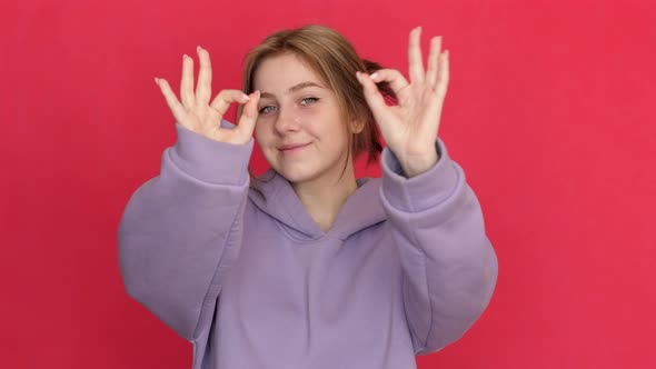 Caucasian smiling young woman attractive in sportswear 20-21 years old shows fingers gesture ok. Stu