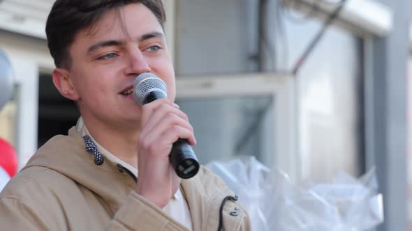 Young Man Talking Into a Microphone