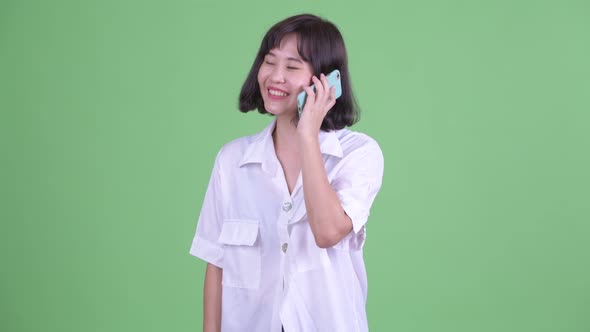 Happy Beautiful Asian Businesswoman Talking on the Phone