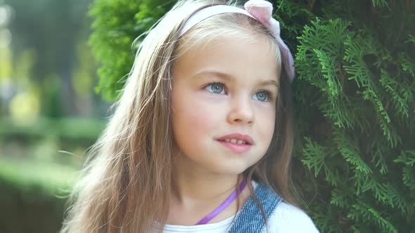 Portrait of Pretty Child Girl Standing Outdoors in Summer Park Smiling Happily