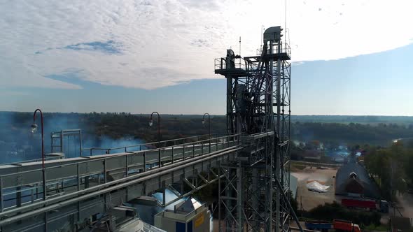 Top of industrial plant. Modern elevators and metal tower on nature background.