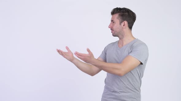 Young Happy Hispanic Man Showing Something