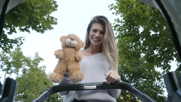 Baby's Point of View, Cheerful Young Caucasian Mother Playing Teddy Bear and Smiling To Infant in