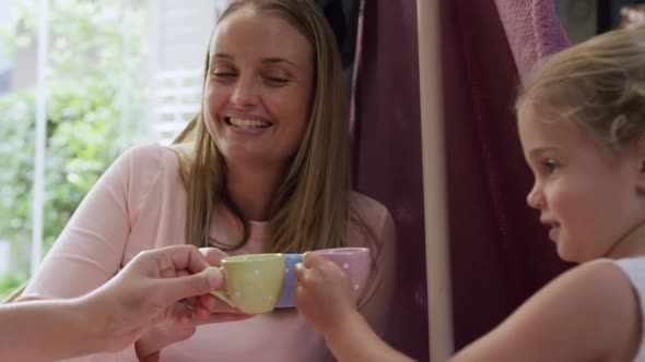 Mother and daughters playing dinette together