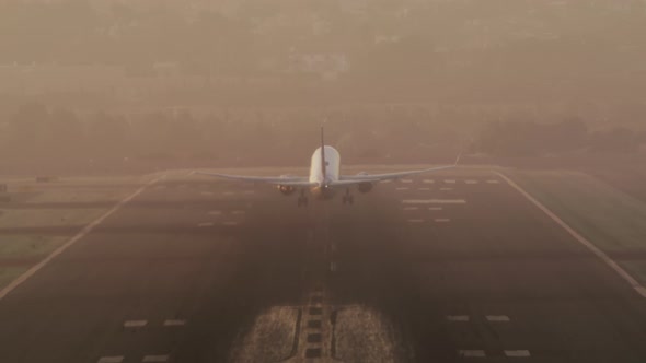 Passenger Airplane Gaining Speed with a Cityscape in the Background alt