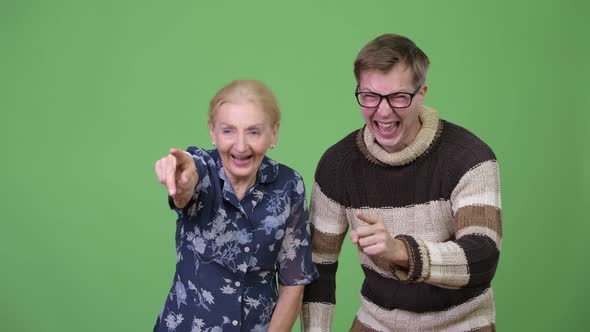 Happy Grandmother and Grandson Laughing While Pointing Finger Together