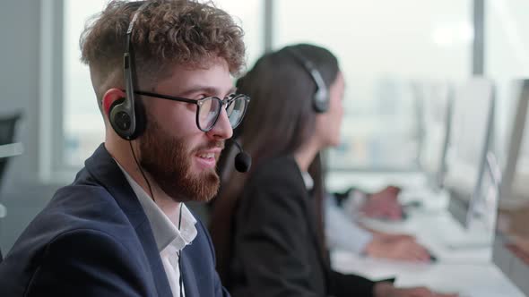 Portrait of a Technical Customer Support Specialist Talking on a Headset While Working on a Computer