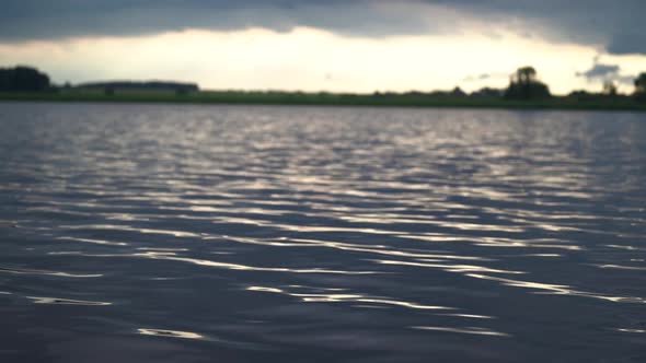 Beautiful View on Blue Lake Surface with Ripples Forest on Bank and Sky