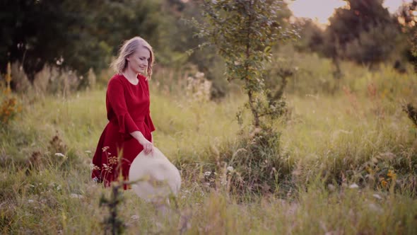 Woman Walking Down the Alley in the Meadow in Summer