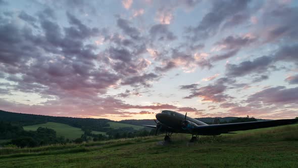 Colorful Clouds Sunset Sky over Old Military Aircraft in Green Nature Landscape