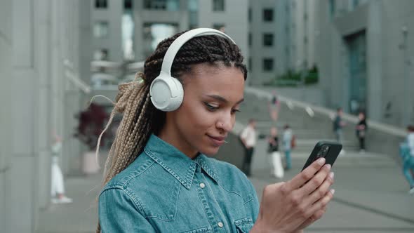 Mixed Race Girl Using Smartphone and Headphones While Listening Music Playlist Technology and Trendy