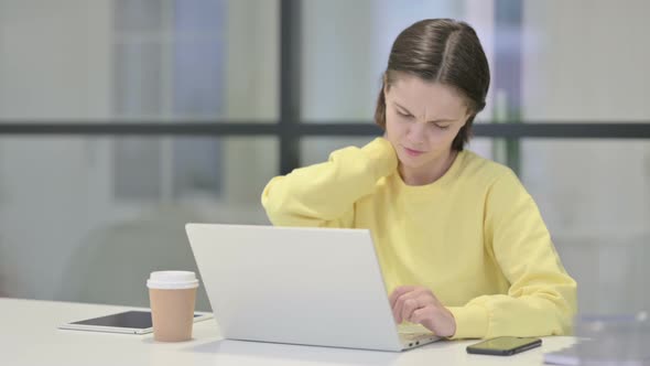 Young Woman Having Neck Pain While Using Laptop in Office