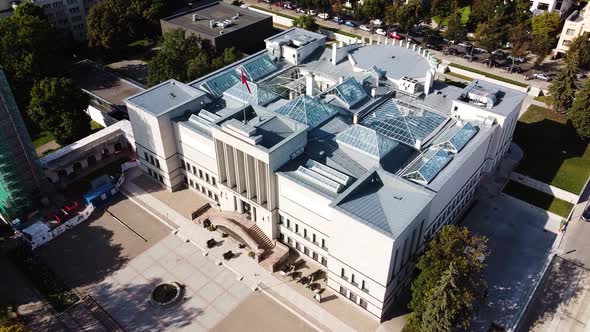 War Museum of Kaunas city with waving red flag of Coats of Arms of Lithuania. Aerial static shot.