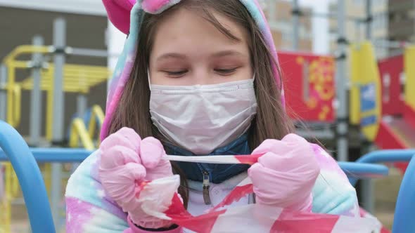 Young Girl in a Protective Mask at the Playground.