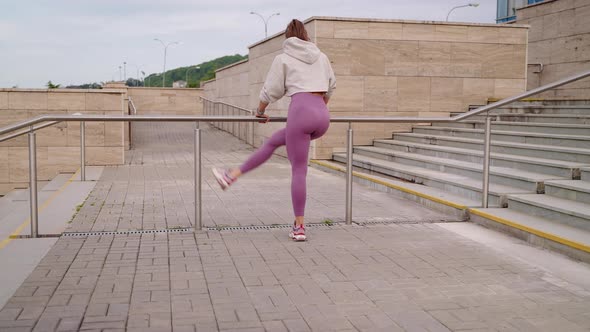 Woman is Training Her Body for Good Looking Waving Legs Outdoors