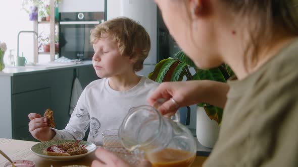 Little Boy Eating and Speaking with Lesbian Mothers on Breakfast