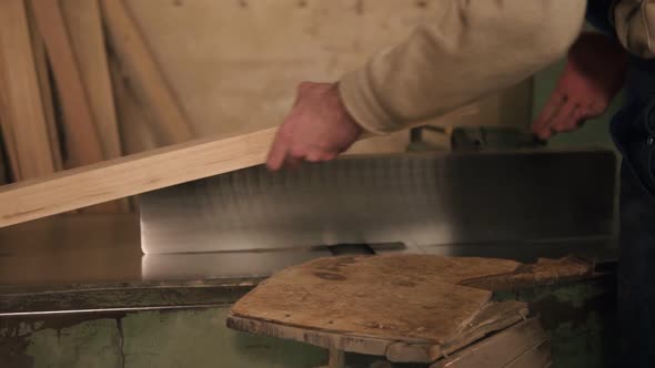 Man in Overalls Polish and Align Boards with Electric Saw in a Carpentry Workshop