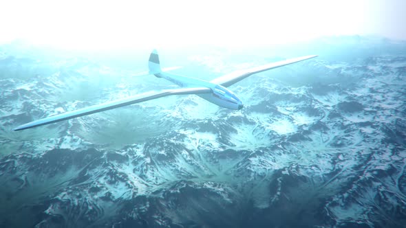 The white sailplane calmly gliding in the sky over the snow-covered mountains.