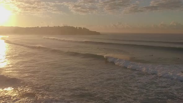 Surfer at Bondi Beach getting a nice long wave to start the day. The shot is wide showing the beach