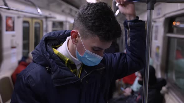 Teen Boy in Face Mask Riding in Underground Subway