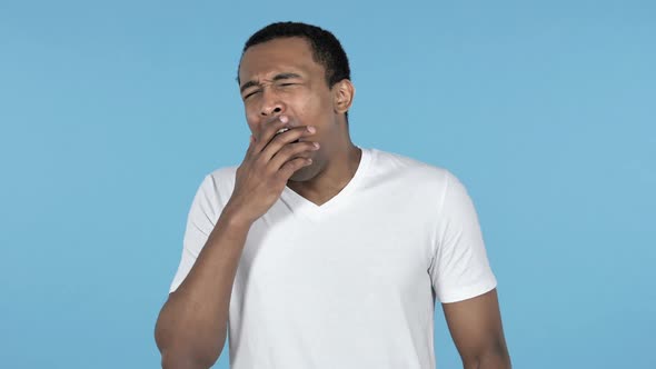 Yawning Young African Man Stretching Body Blue Background