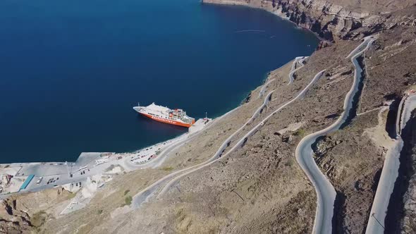 4k Aerial drone view over Santorini port winding road