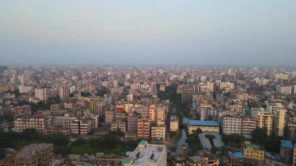 Aerial View Over Dense Metropolitan Cityscape In Asia Against Hazy Skies. Dolly Forward, Establishin