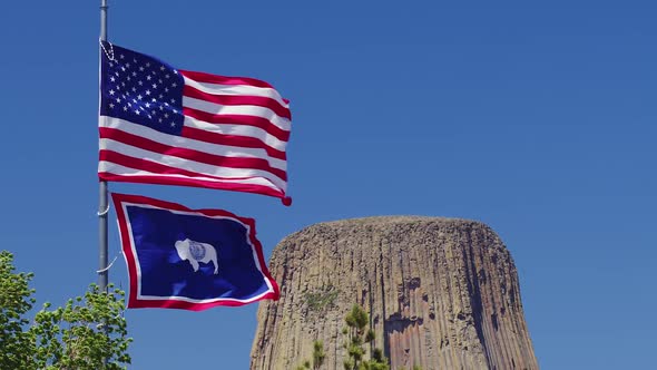 United States of America and Wyoming flags waving in the wind at Devils Tower