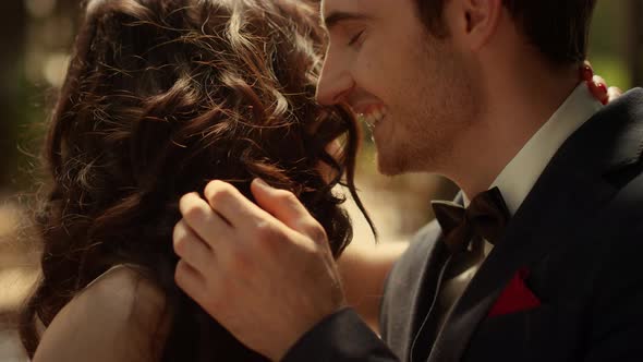 Cheerful Couple Laughing in Garden. Attractive Man Smelling Woman Hair Outdoors