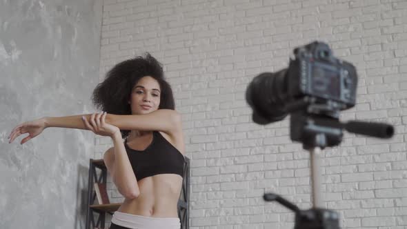 Young African American Lady Is Stretching Her Arms Stretching in Front of the Camera.