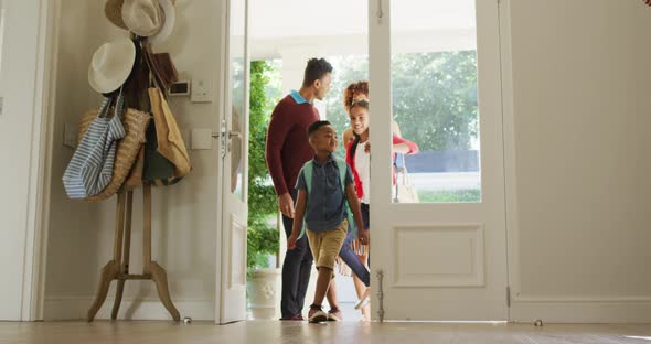 Happy african american family entering the house from front door