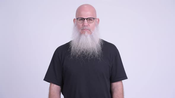 Mature Bald Bearded Man with Finger on Lips