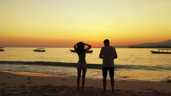 Fun couple on romantic honeymoon enjoy life on beach on paradise white sand background 4K