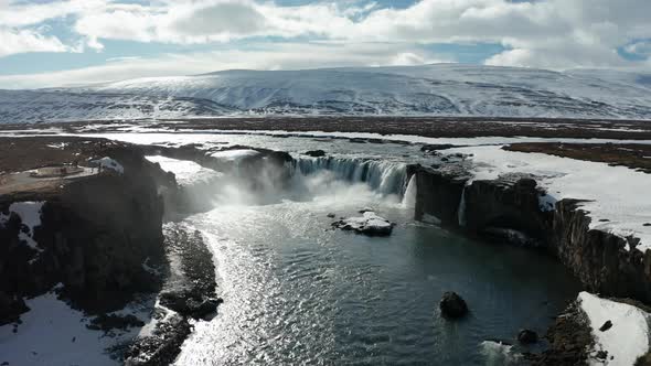 Aerial View of Godafoss Waterfall with Snowy Shore and Ice. Iceland. Winter 2019